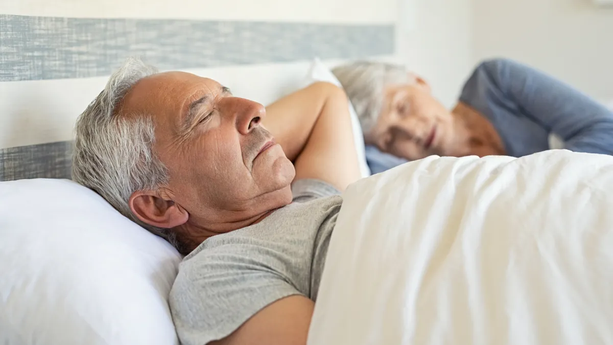 Personne dormant paisiblement dans une chambre sombre et calme, optimisée pour soulager les douleurs de fibromyalgie.