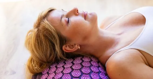 Femme détendue sur un tapis d'acupression Ayurcomfort - relaxation et bien-être