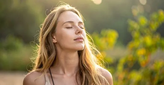 Femme sereine pratiquant la méditation ayurvédique en pleine nature - bien-être Ayurcomfort